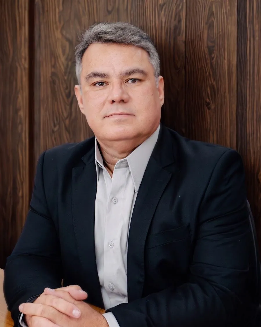 Executivo revisando documentos com pátio logístico ao fundo